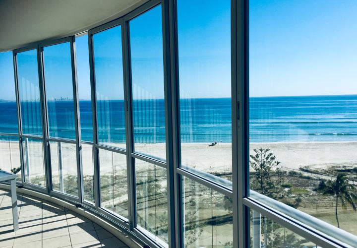 Floor to ceiling windows looking out at a beach